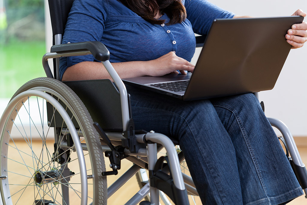 Girl in wheelchair using laptop